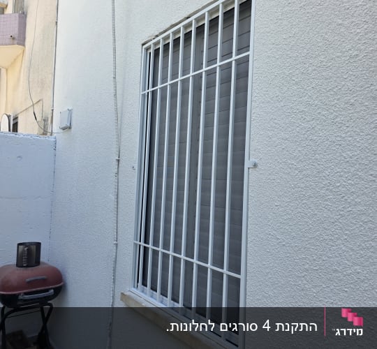 סורגים ישרים ממתכת בצבע לבן המותקנים על חלון חיצוני